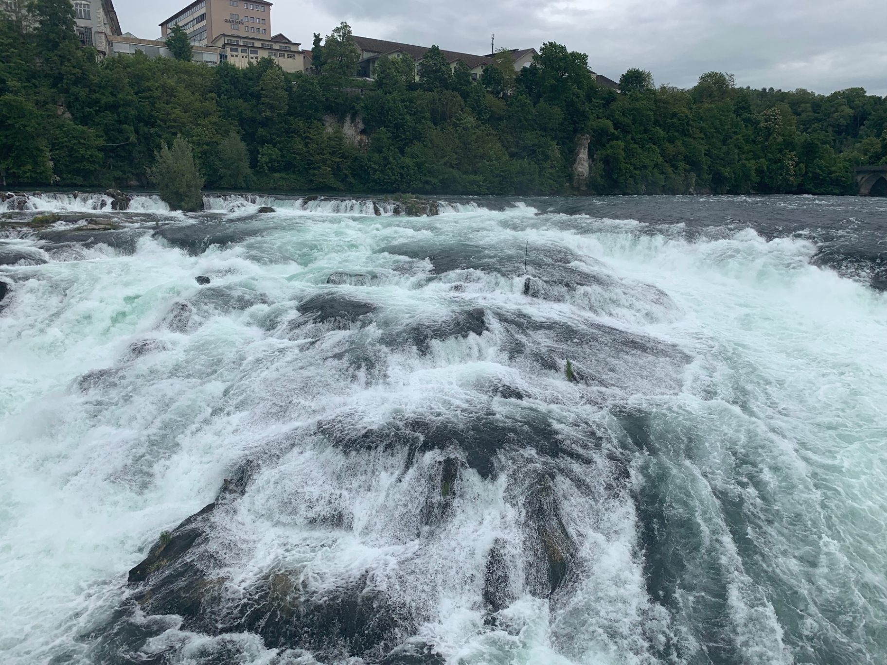 Close-up of churning white water pouring over the river rocks of the Rhine
