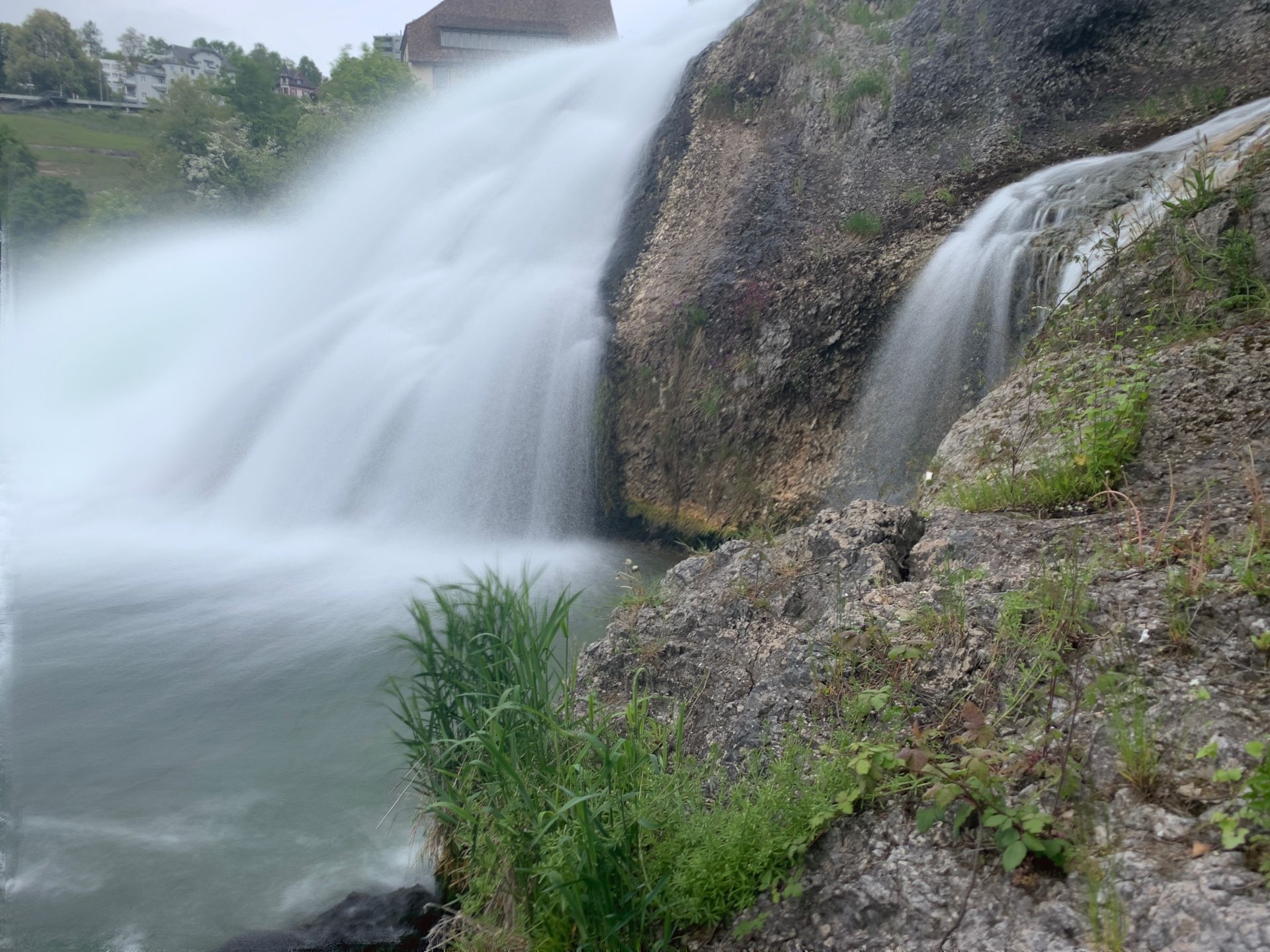 Water cascading over dark rock ledges at the side of the Rhine Falls