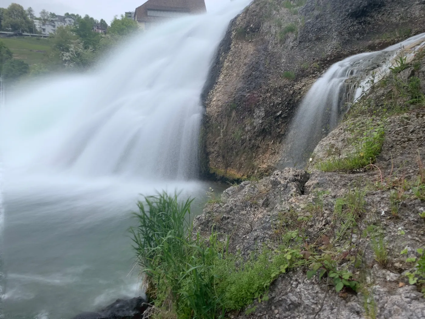 Water cascading over dark rock ledges at the side of the Rhine Falls