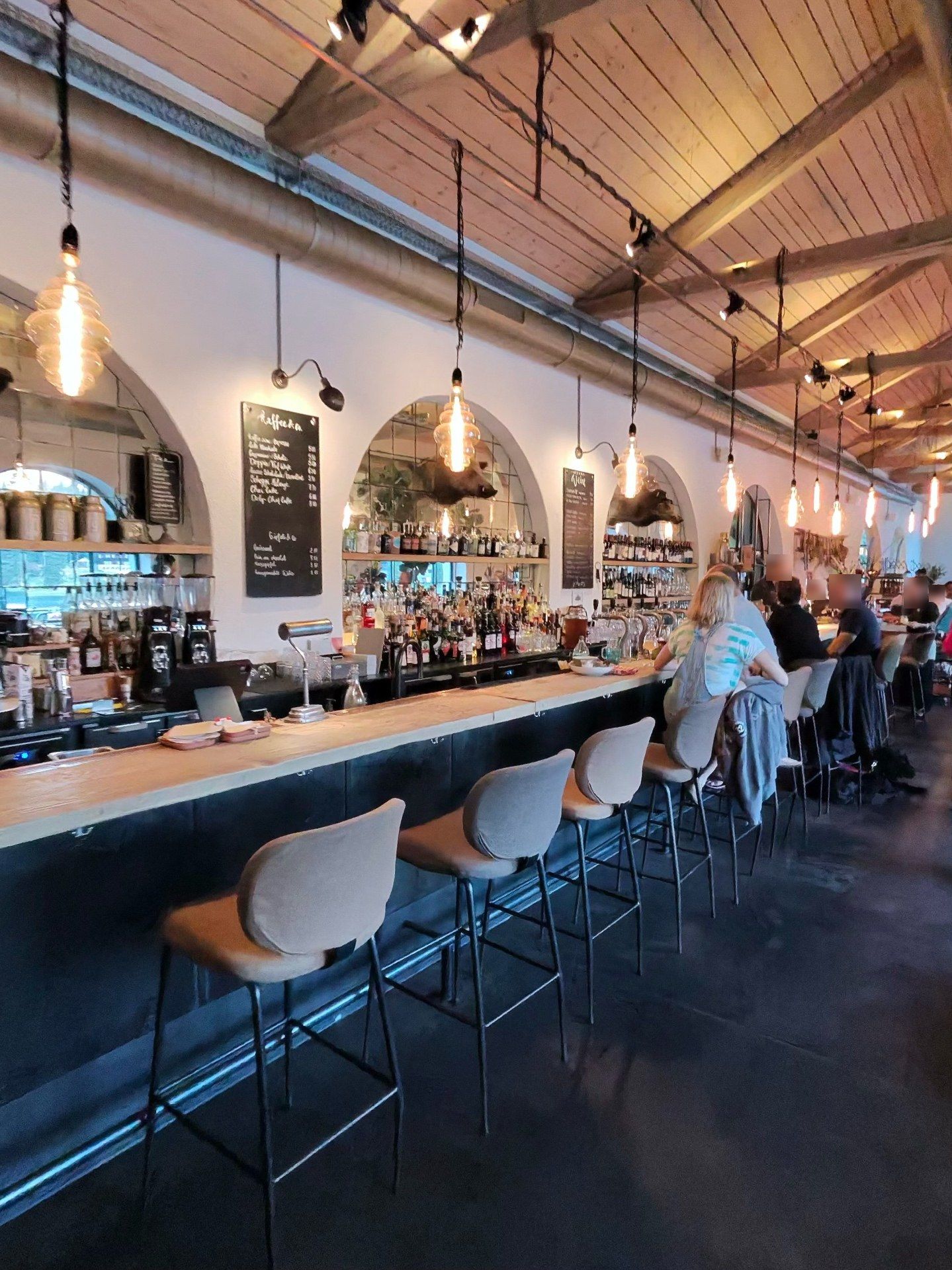 The Güterschuppen bar in Arosa: a converted railway goods shed with timber ceiling, arched mirrors and Edison bulbs