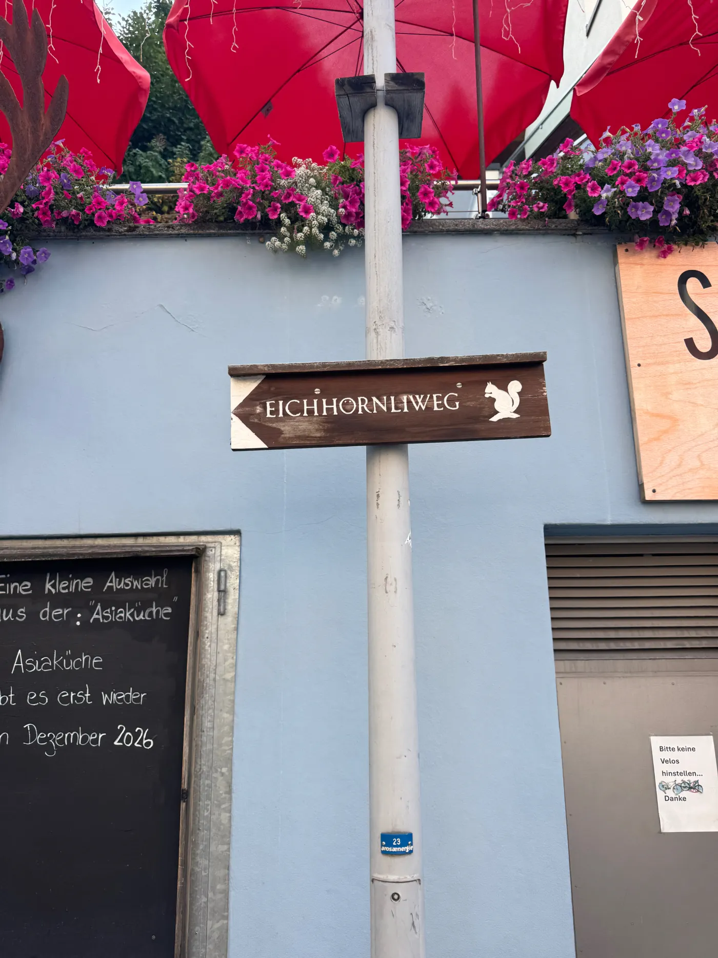 Wooden Eichhornliweg trail signpost with a painted squirrel, Arosa