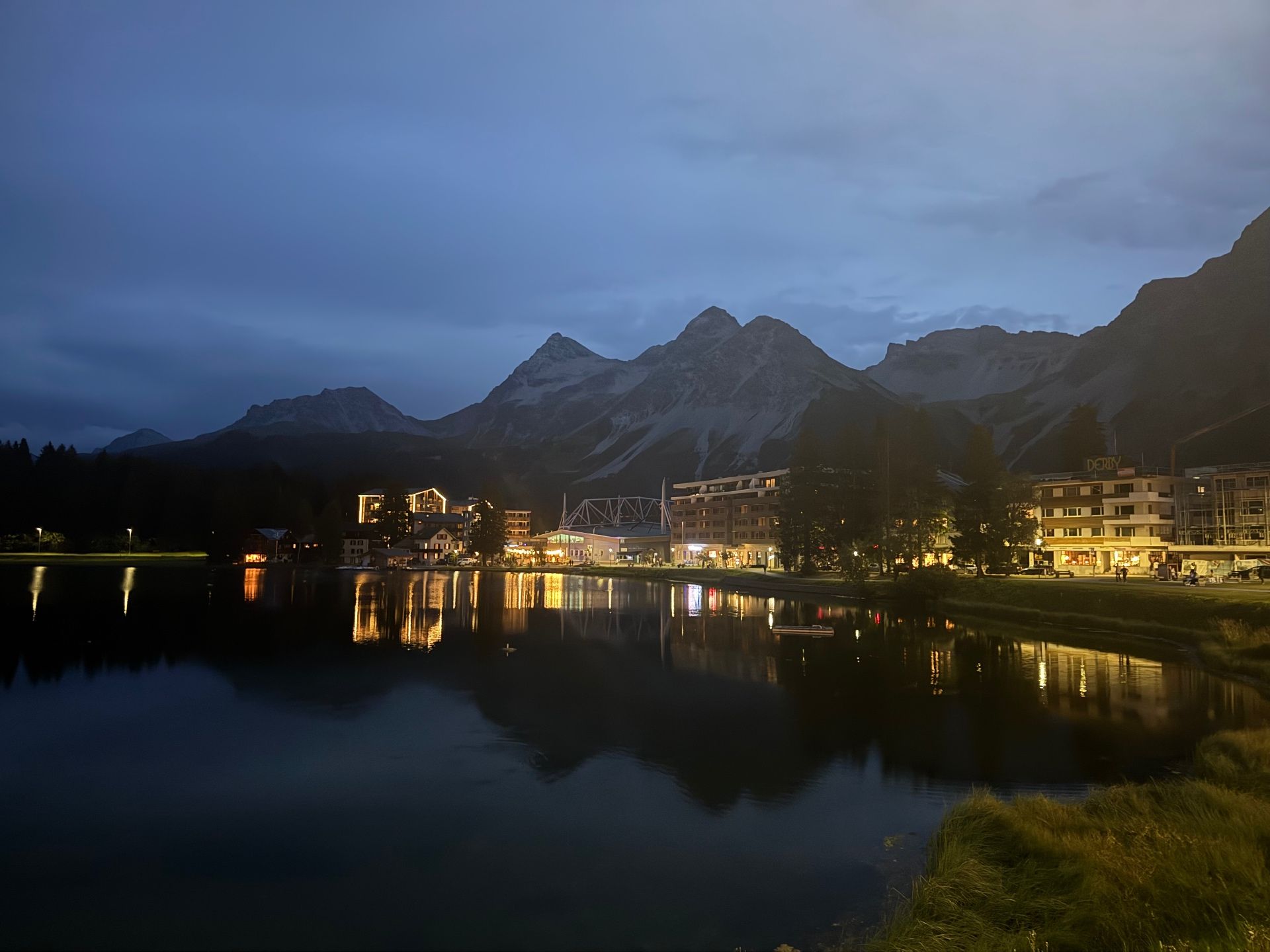 Town lights reflected on Arosa's Obersee at blue hour