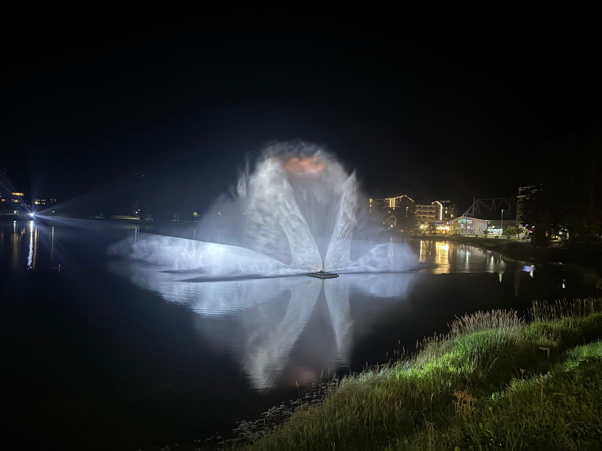 The AquaLumina water-and-light show lit up on the dark Obersee in Arosa