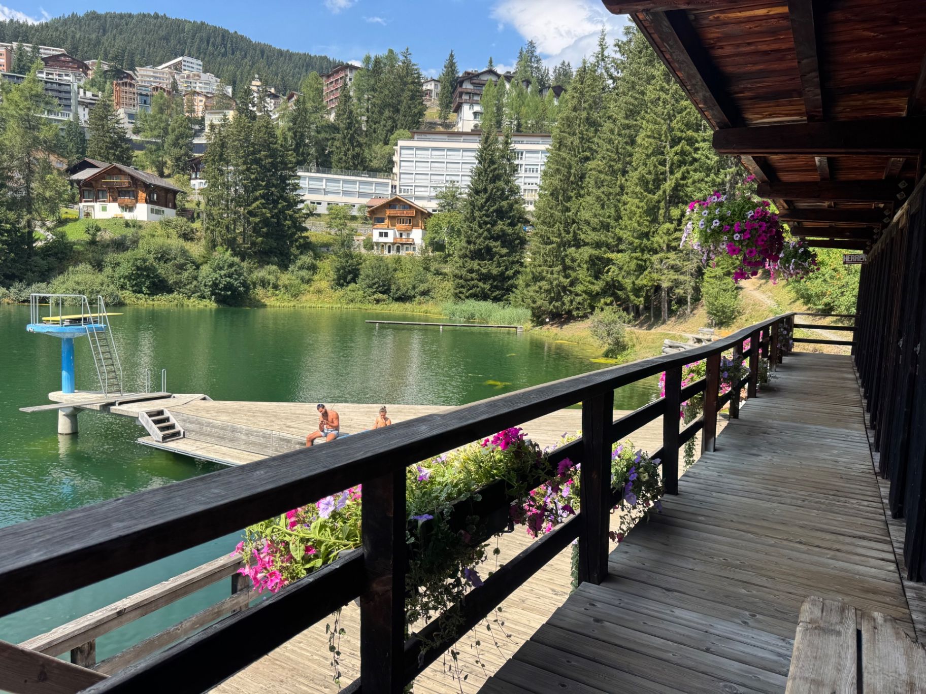 The Untersee lido in Arosa: blue diving tower, swim platform and flower-lined boardwalk
