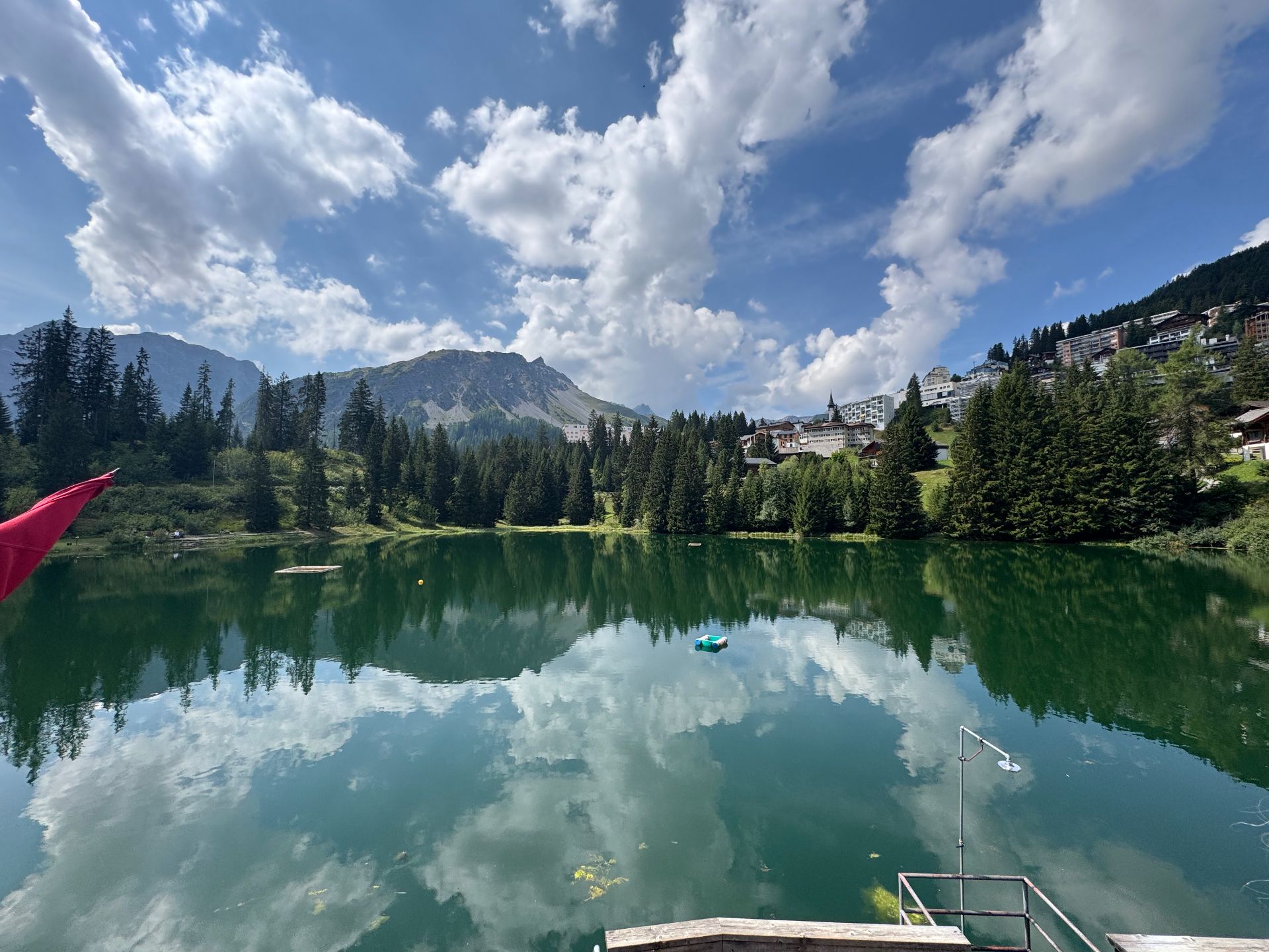 Arosa's Untersee as a still mirror, peaks and clouds reflected on the surface